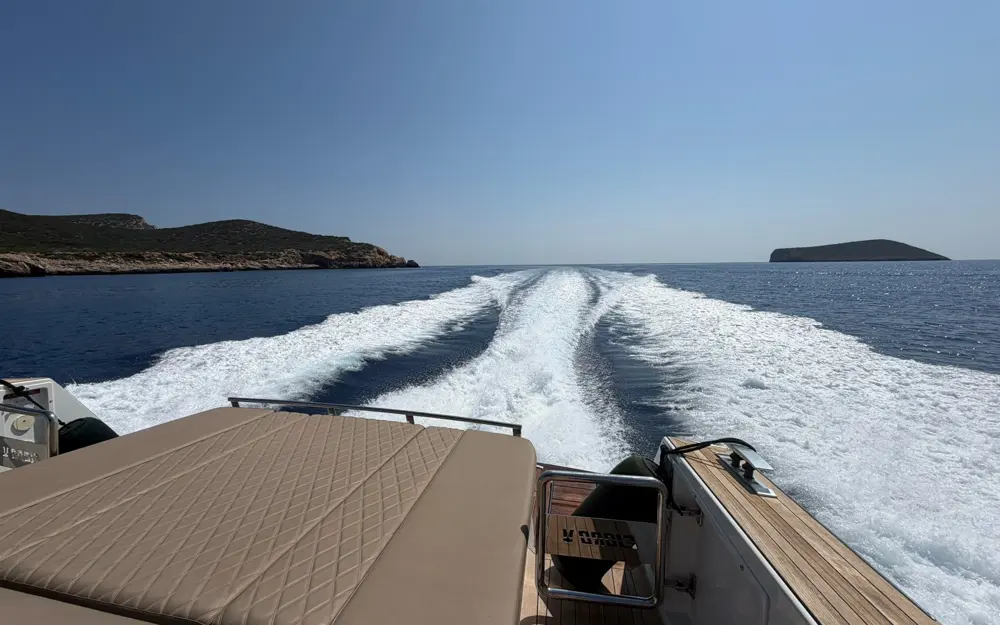 Blick über das Heck der Fjord 52 „Peanuts“ auf das weiße Kielwasser vor der Küste