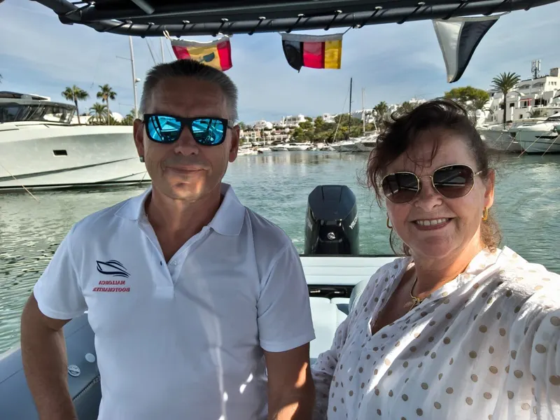 Stefan and Sabrina Röske in the harbour of Cala d'Or, the boats behind them