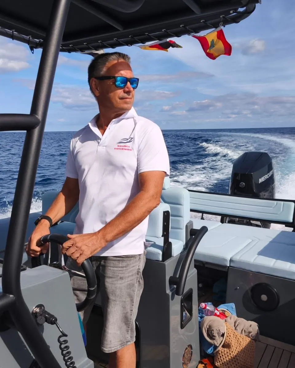 Stefan Röske al timón de la semirrígida “Pino”, detrás la estela frente a la costa de Cala d'Or