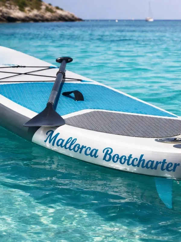 Stand-up-Paddle-Board mit dem Schriftzug Mallorca Bootcharter auf türkisem Wasser