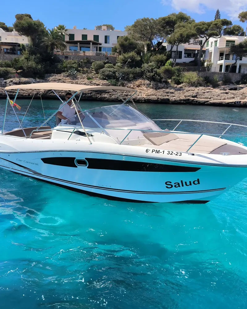 The Cap Camarat 8.5 “Salud” in turquoise water in front of the white houses of Cala d'Or